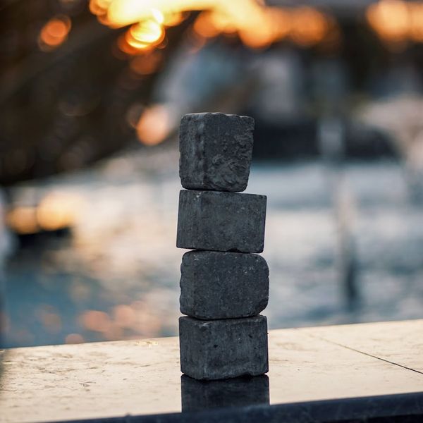 Abstract image showing balance with stacked stones near water.